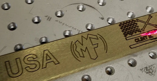 A close-up of a gold-colored open end wrench with 'USA' and 'MF' stamped on it, indicating it is an American product made by Mass Fabricator.
