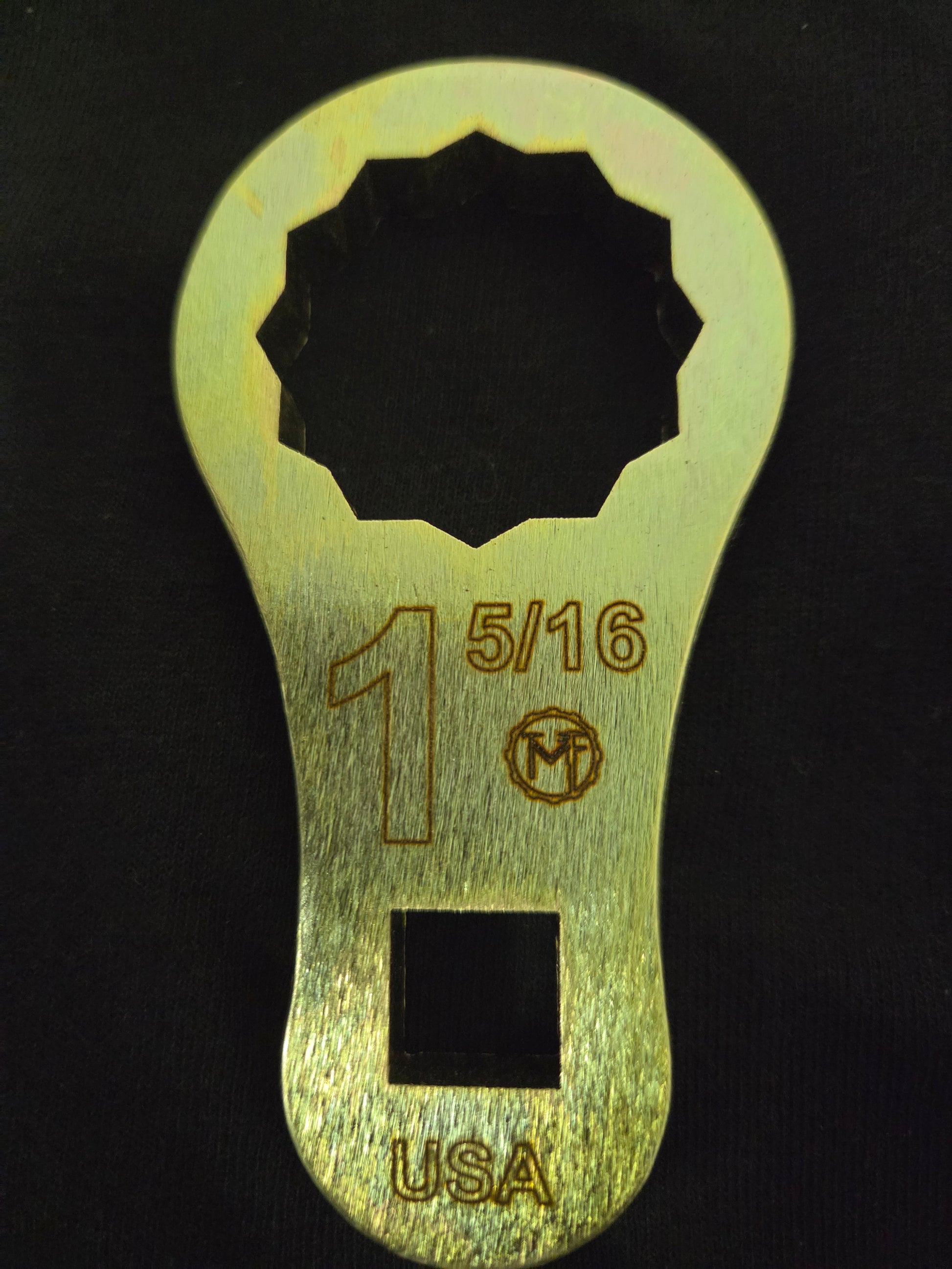 Metal wrench with size marking '15/16' on a black background