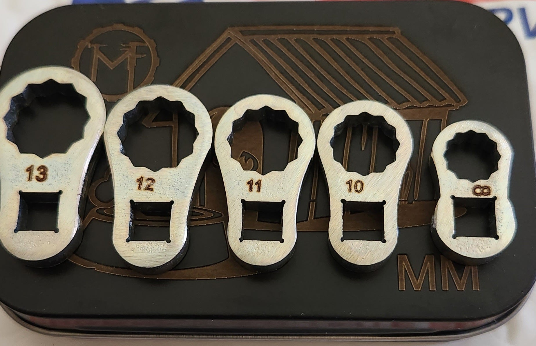 A set of five bulletproof metal dog bone-shaped wrenches 8mm-13mm. The dog bone tool is engineered for durability, alignment, and consistent performance in demanding applications. Manufactured from ar500 steel, it offers exceptional hardness, high impact resistance, and outstanding wear life, making it ideal for repeated heavy use. 